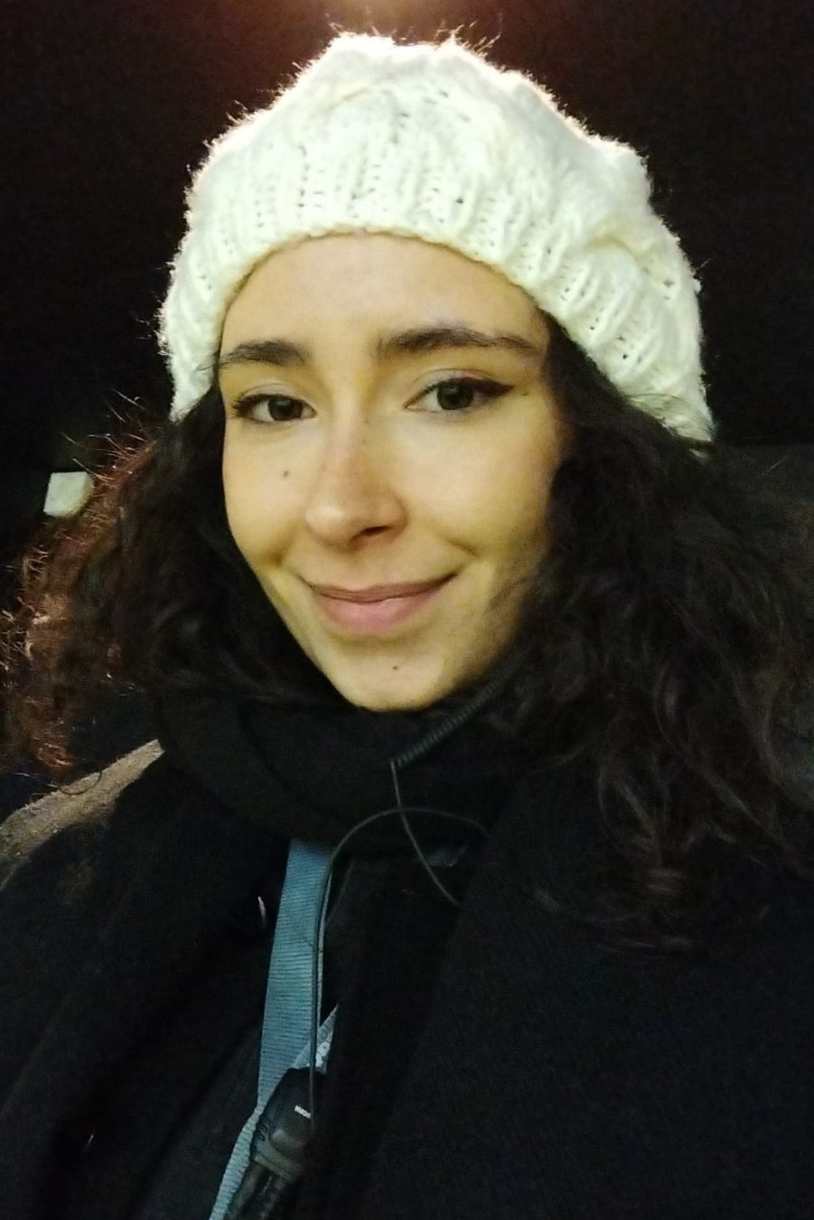 Mulher sorridente com gorro de l&atilde; branco